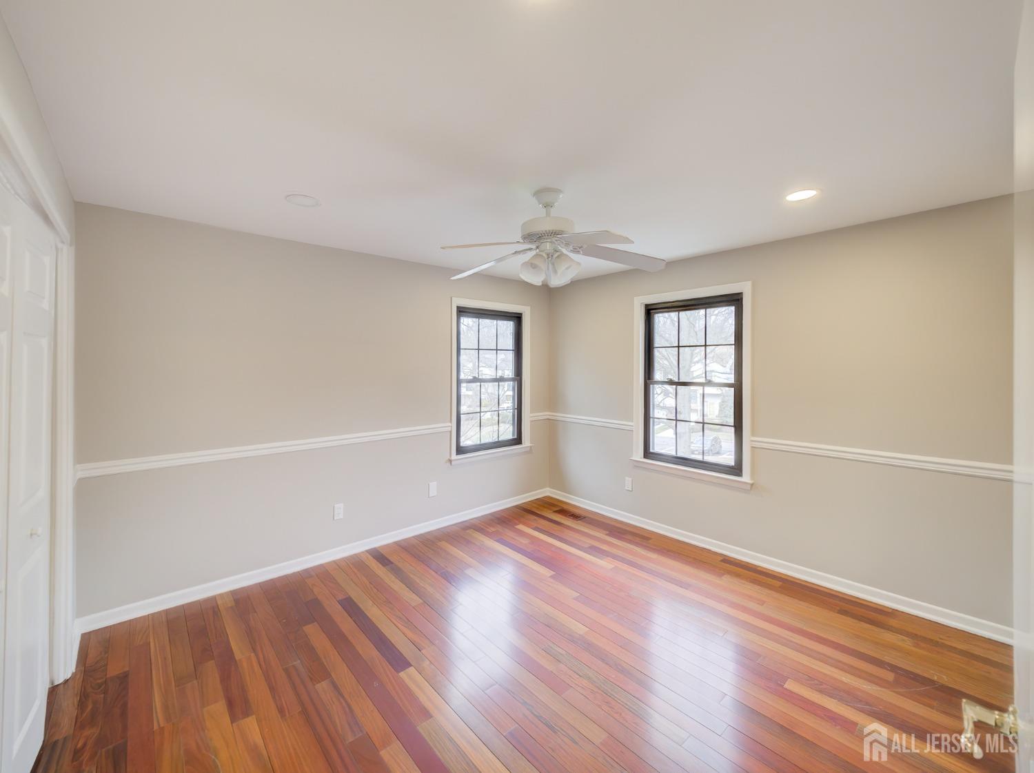 4905 Stonehedge Road Edison, NJ 08820 - Photo 21 of 43 an empty room with wooden floor and windows