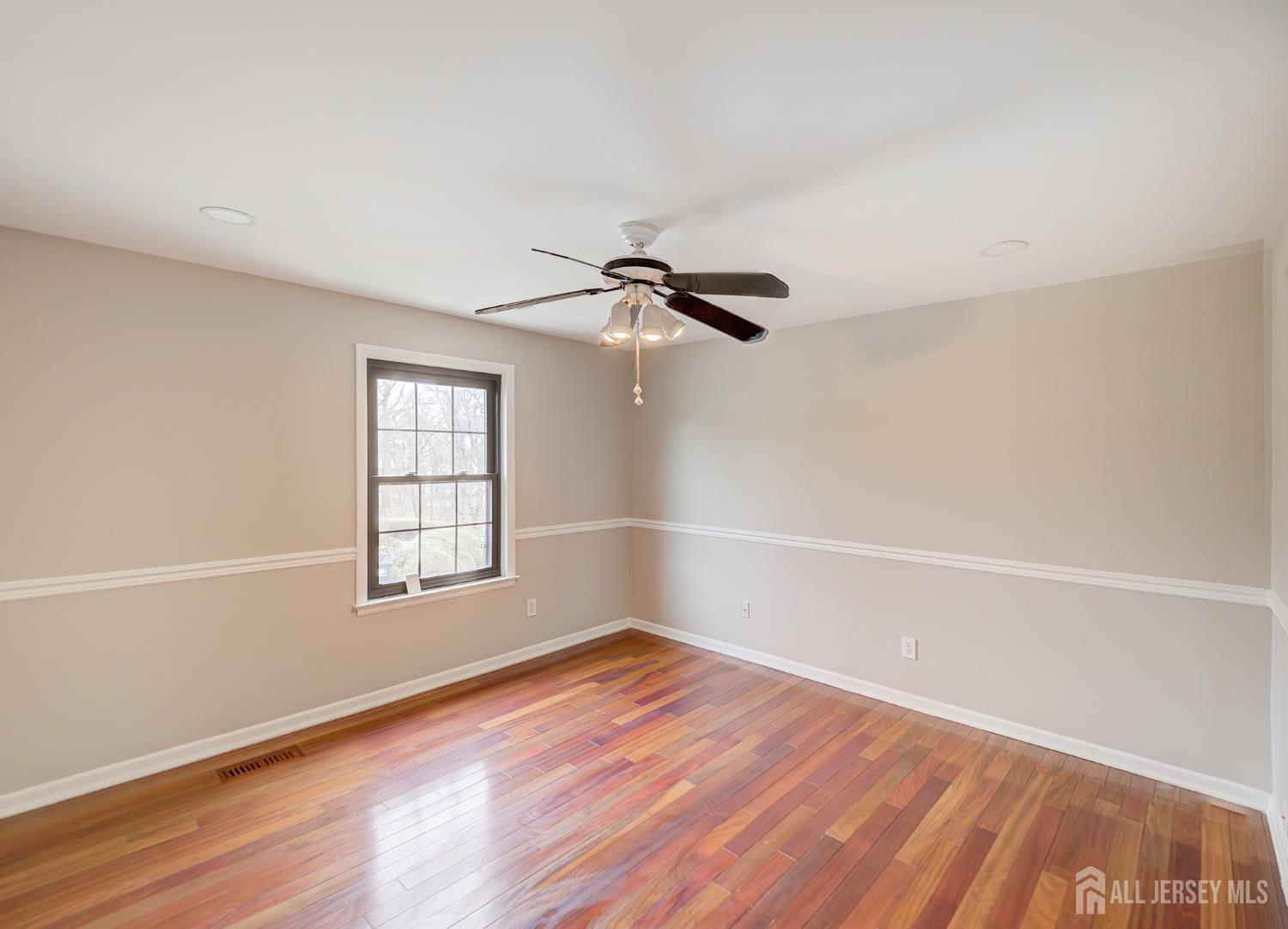 4905 Stonehedge Road Edison, NJ 08820 - Photo 23 of 43 an empty room with wooden floor fan and windows
