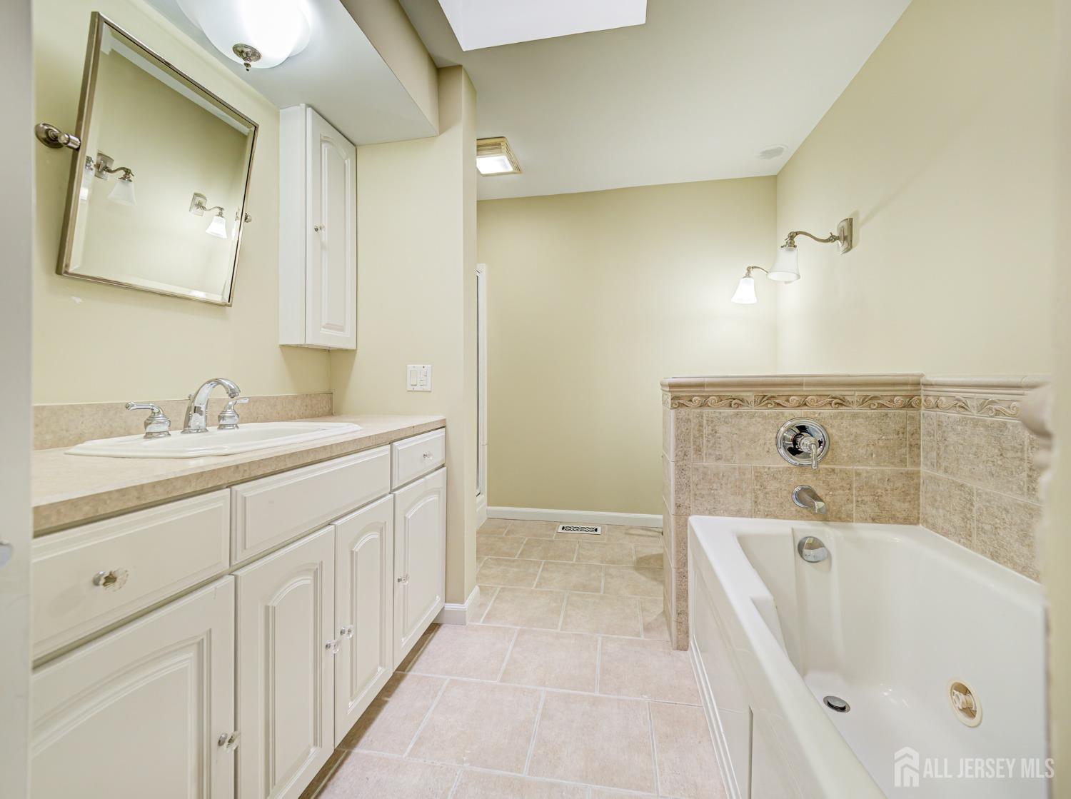 4905 Stonehedge Road Edison, NJ 08820 - Photo 29 of 43 a bathroom with a bathtub sink a mirror and shower
