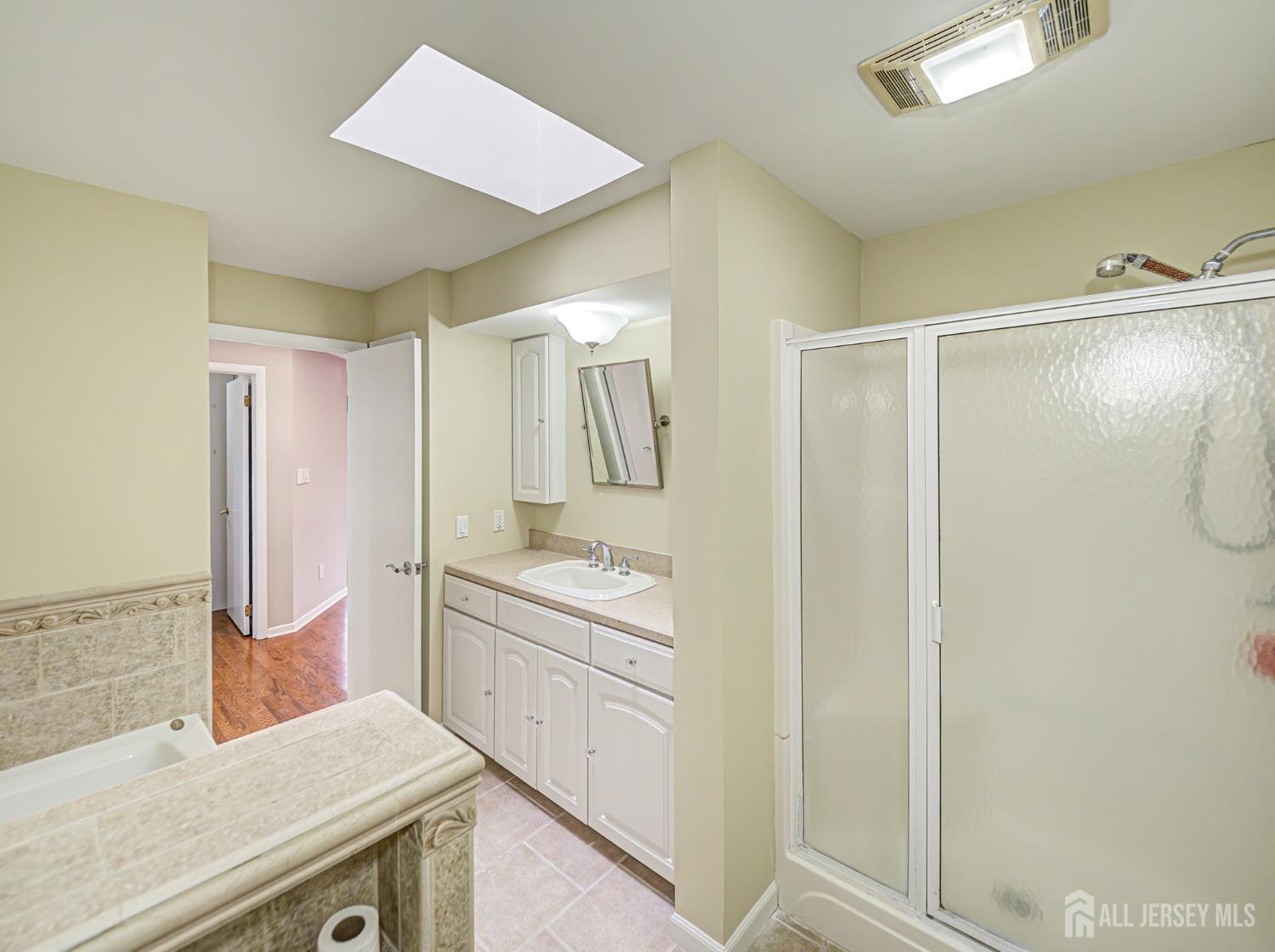 4905 Stonehedge Road Edison, NJ 08820 - Photo 30 of 43 a bathroom with a granite countertop sink a shower and a mirror