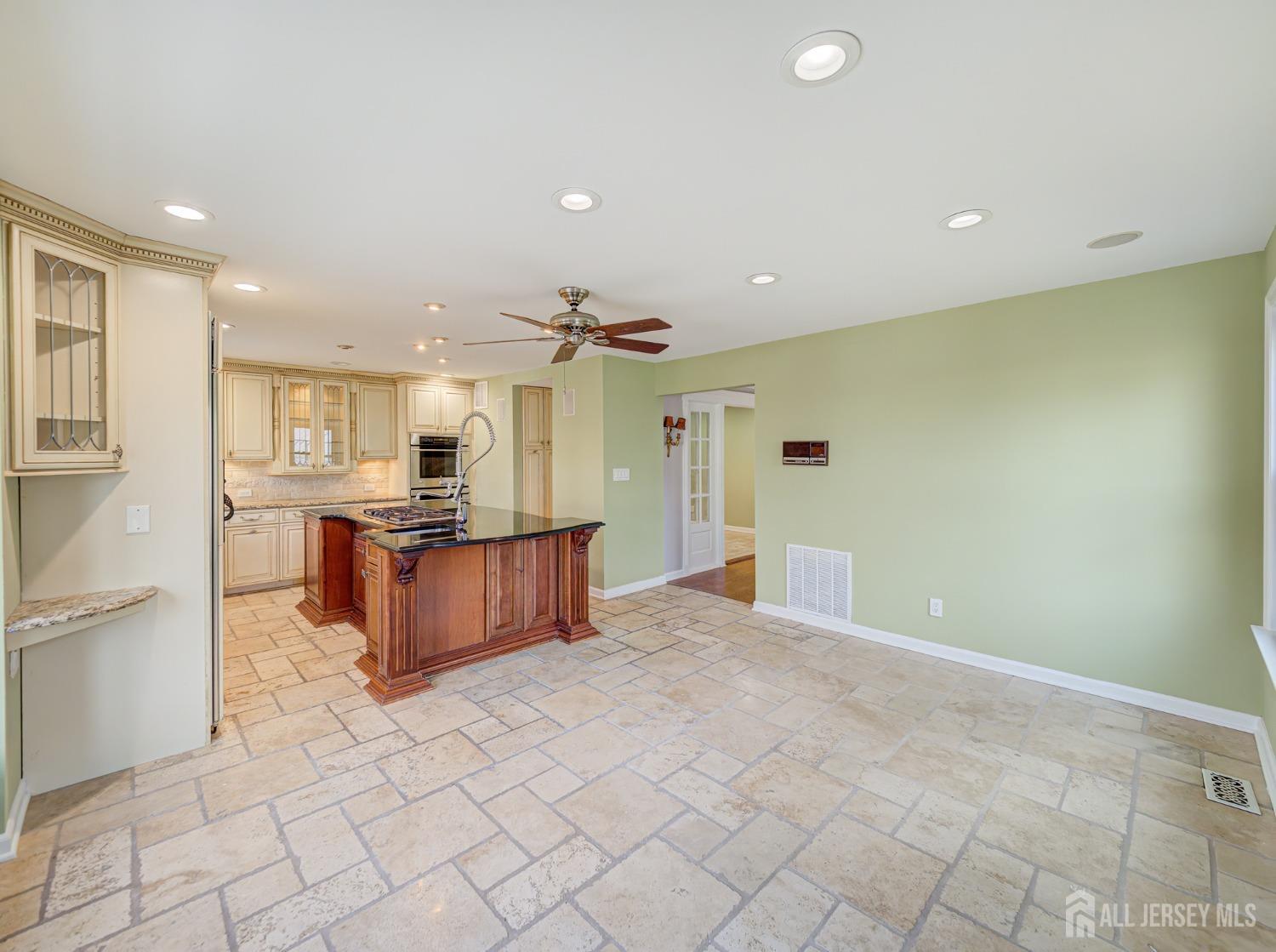 4905 Stonehedge Road Edison, NJ 08820 - Photo 8 of 43 a large kitchen with stainless steel appliances a large counter top and a stove top oven