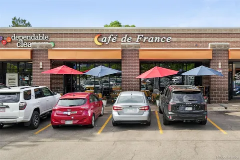 a front view of a house with a garden and plants