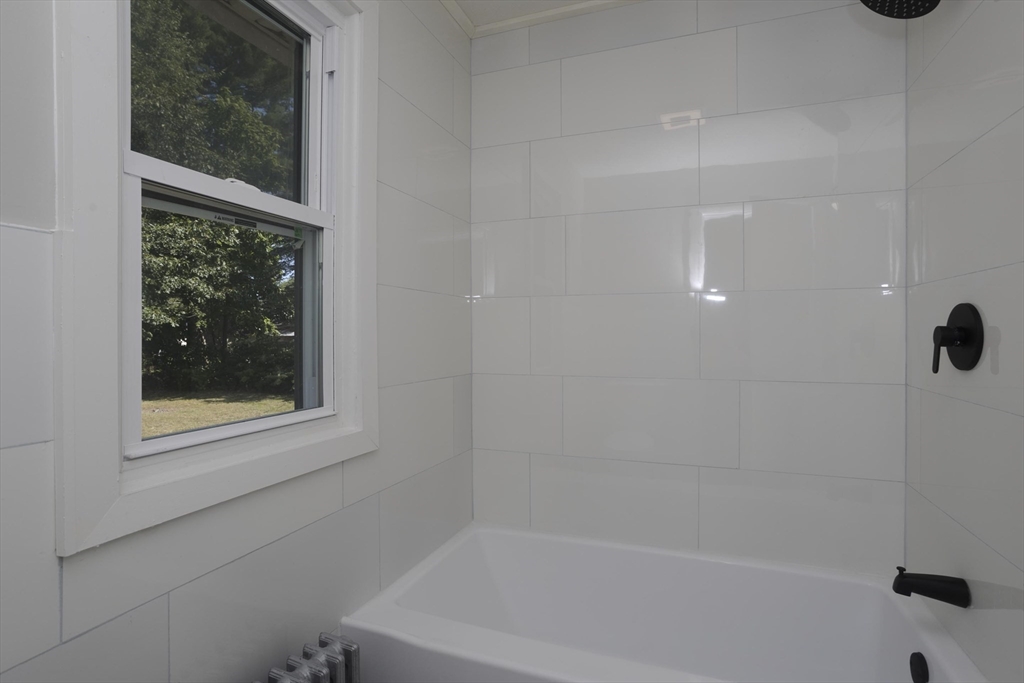 69 Merrimac Avenue Springfield, MA 01104 - Photo 12 of 42 a white bath tub sitting next to a window