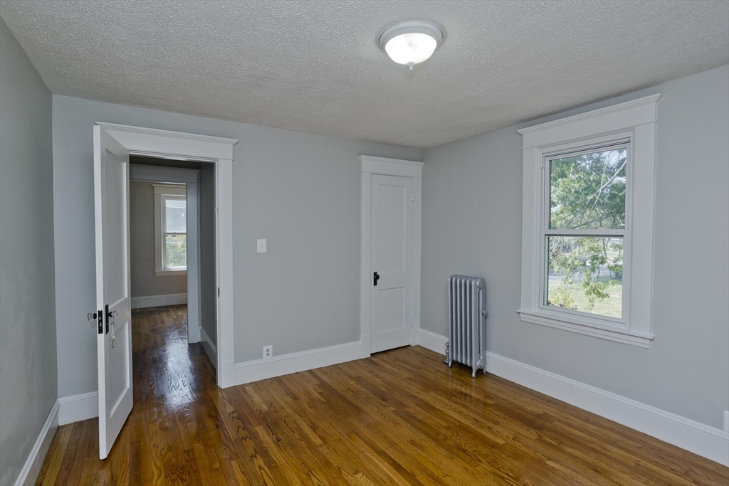 69 Merrimac Avenue Springfield, MA 01104 - Photo 14 of 42 an empty room with wooden floor and a window