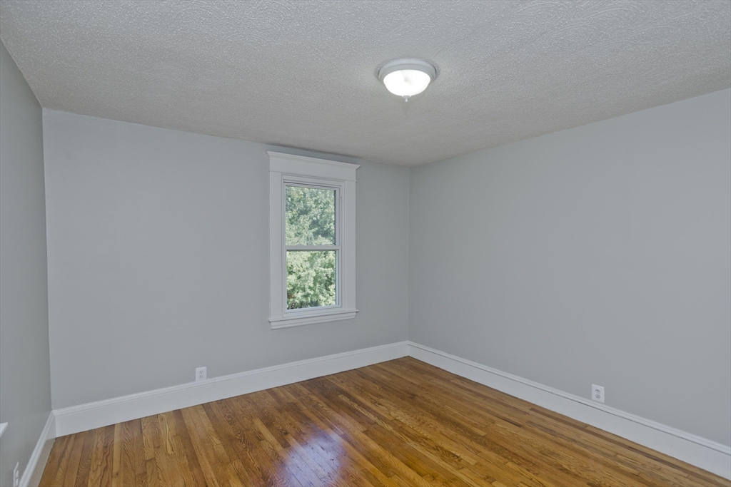 69 Merrimac Avenue Springfield, MA 01104 - Photo 18 of 42 an empty room with wooden floor and windows