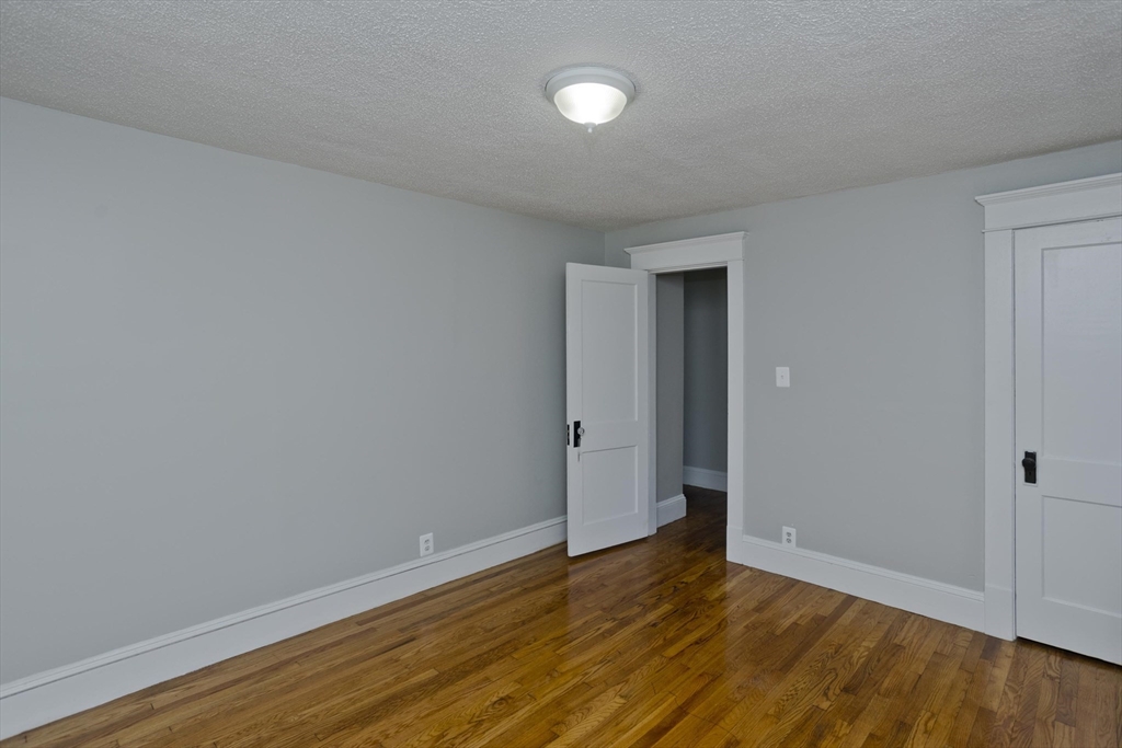 69 Merrimac Avenue Springfield, MA 01104 - Photo 19 of 42 a view of an empty room with wooden floor and a window