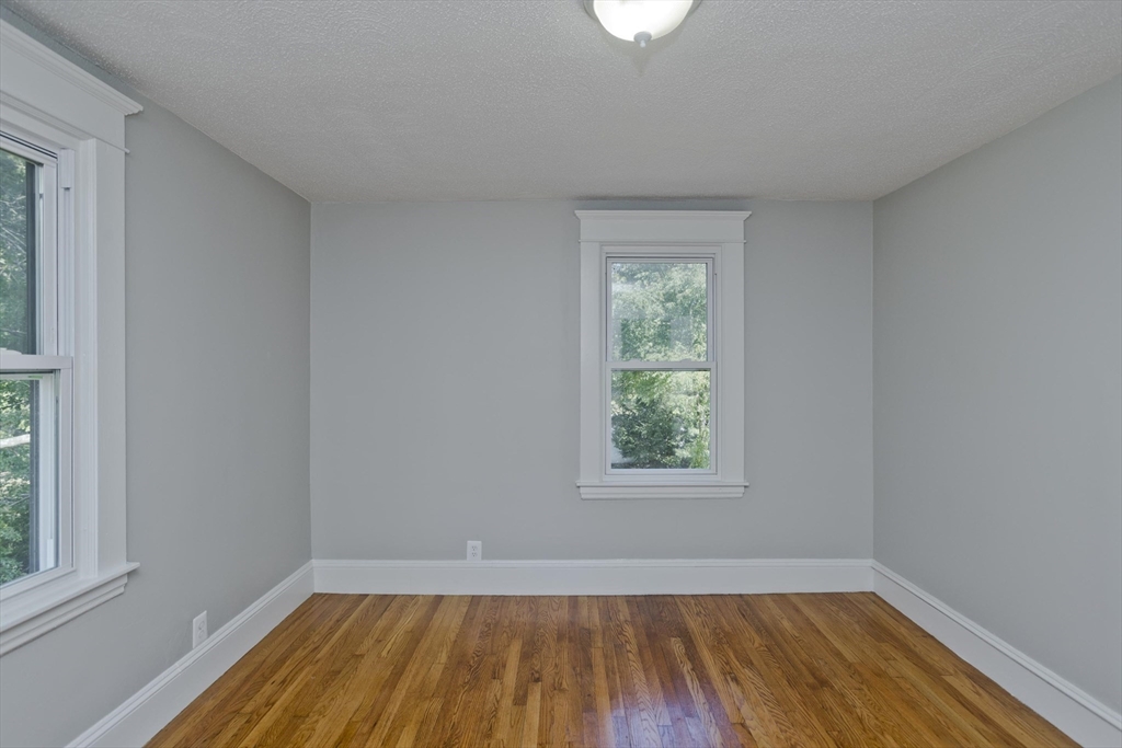 69 Merrimac Avenue Springfield, MA 01104 - Photo 20 of 42 a view of an empty room with wooden floor and a window