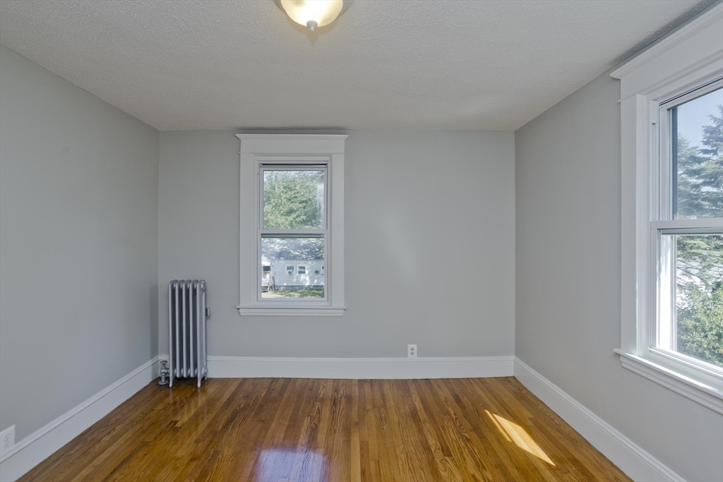69 Merrimac Avenue Springfield, MA 01104 - Photo 23 of 42 an empty room with wooden floor and windows