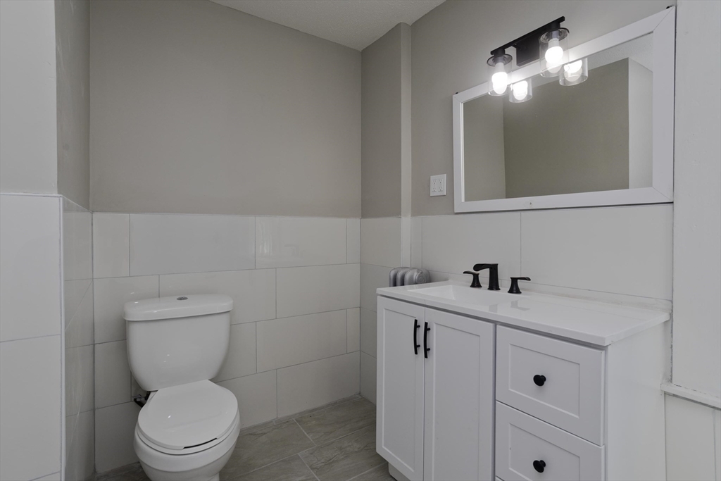 69 Merrimac Avenue Springfield, MA 01104 - Photo 26 of 42 a bathroom with a toilet a sink and mirror