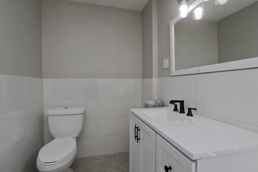 69 Merrimac Avenue Springfield, MA 01104 - Photo 27 of 42 a bathroom with a toilet sink and mirror