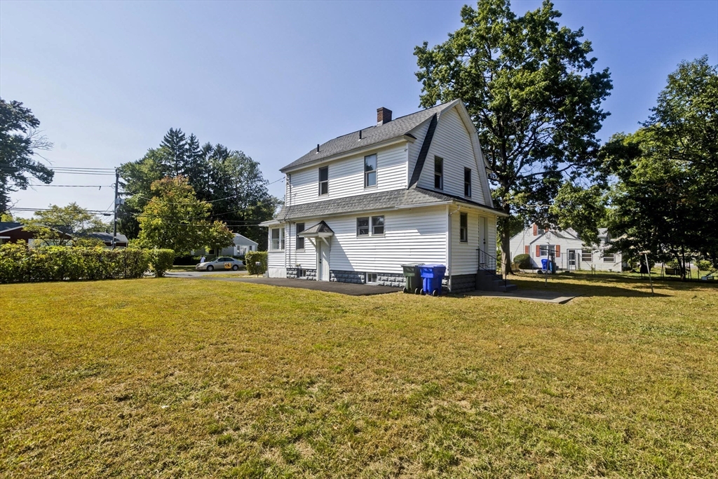 69 Merrimac Avenue Springfield, MA 01104 - Photo 39 of 42 a front view of house with small pool and trees in the background