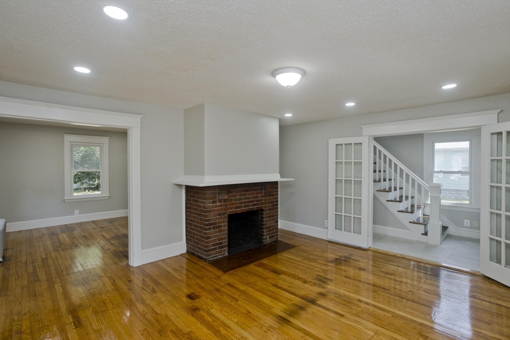 69 Merrimac Avenue Springfield, MA 01104 - Photo 6 of 42 an empty room with wooden floor and fireplace