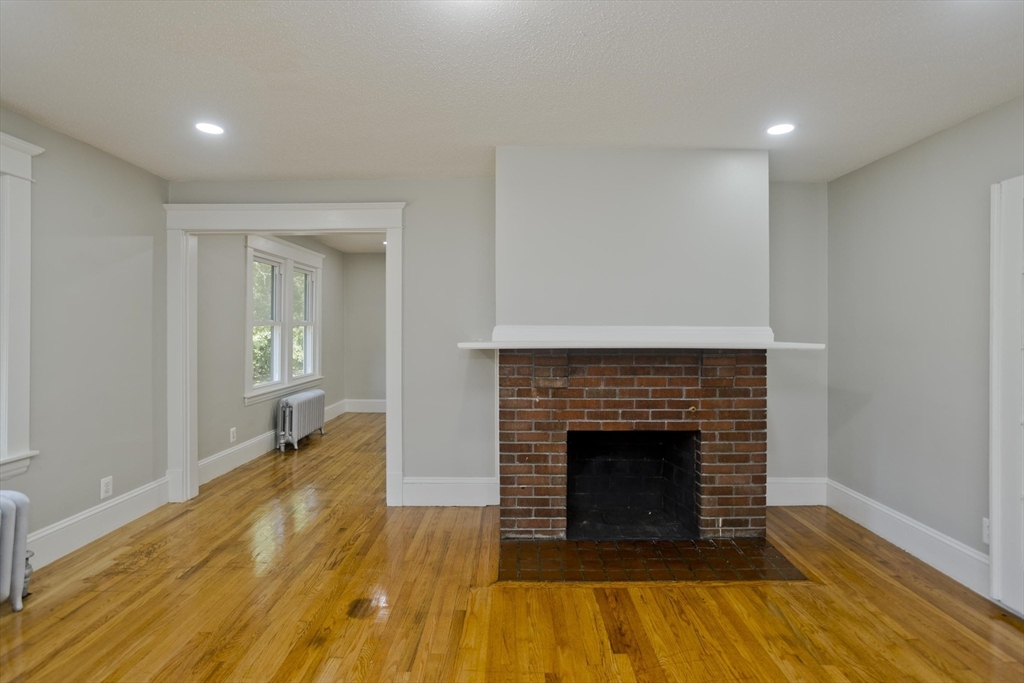 69 Merrimac Avenue Springfield, MA 01104 - Photo 7 of 42 a living room with a fireplace and wooden floor