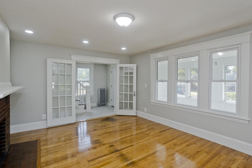 69 Merrimac Avenue Springfield, MA 01104 - Photo 8 of 42 an empty room with wooden floor and windows