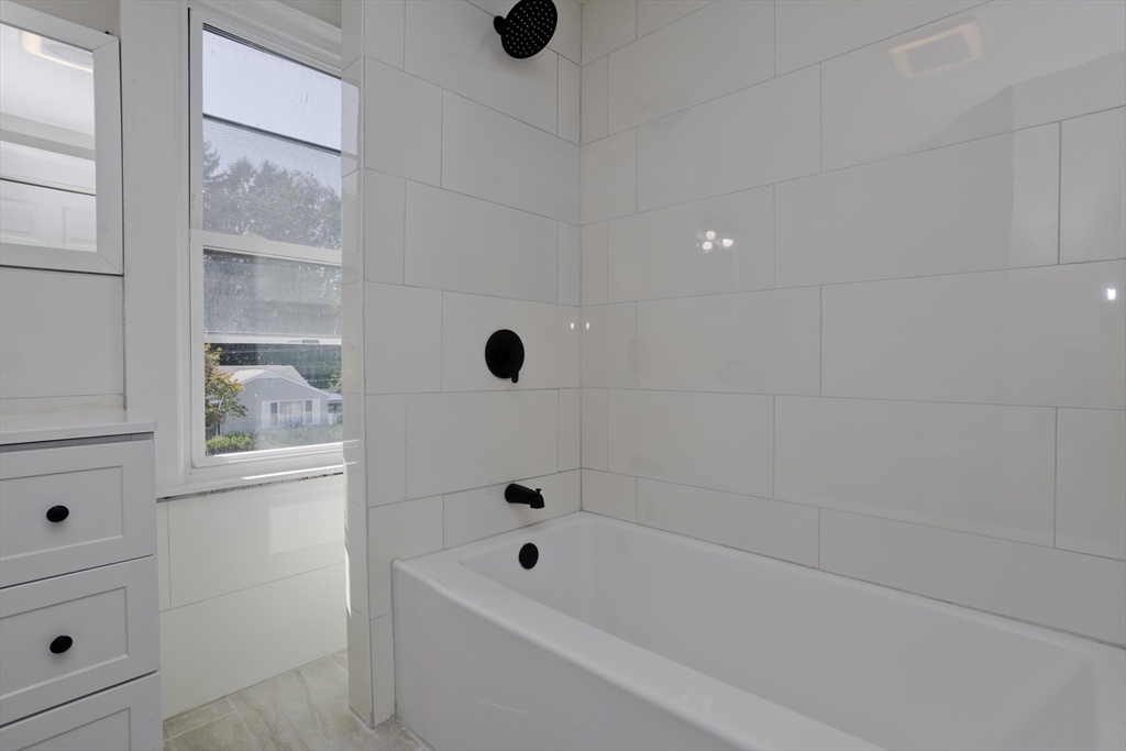 69 Merrimac Avenue Springfield, MA 01104 - Photo 10 of 42 a bathroom with a tub and shower