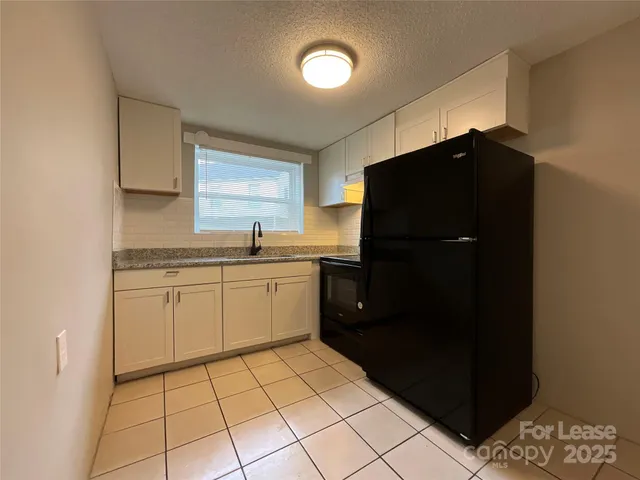 a kitchen with a refrigerator and a sink