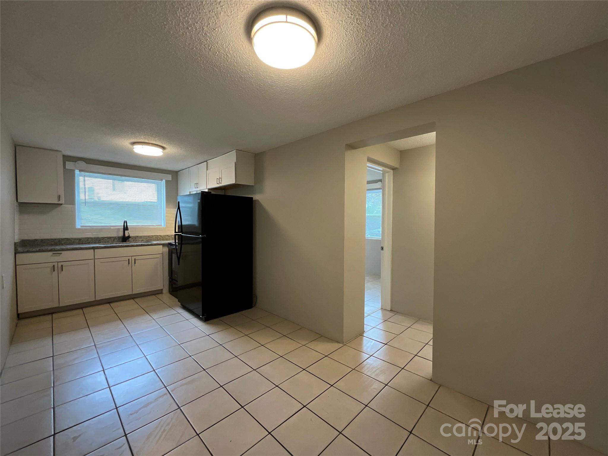 259 Jefferson Court Northeast, Unit 1 Concord, NC 28025 - Photo 6 of 9 a kitchen with a cabinets and a refrigerator