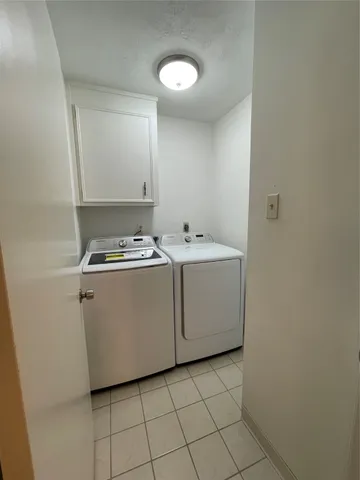 a utility room with cabinets washer and dryer