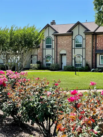 a front view of a house with a big yard and potted plants