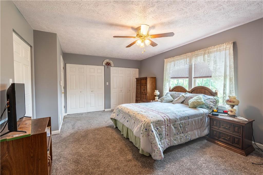 4487 Battle Ridge Road Oakdale, PA 15071 - Photo 23 of 46 a bedroom with a bed and a flat tv screen on dresser