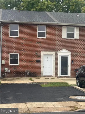 a view of a brick house with a yard