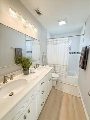a bathroom with a double vanity sink toilet and shower