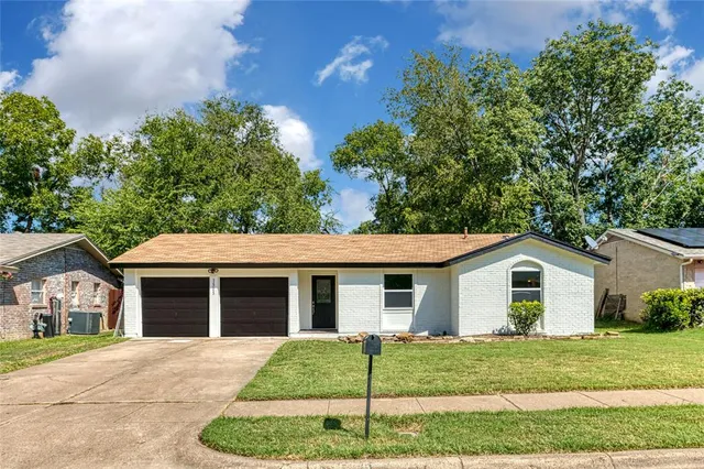a view of a house with a yard and large tree
