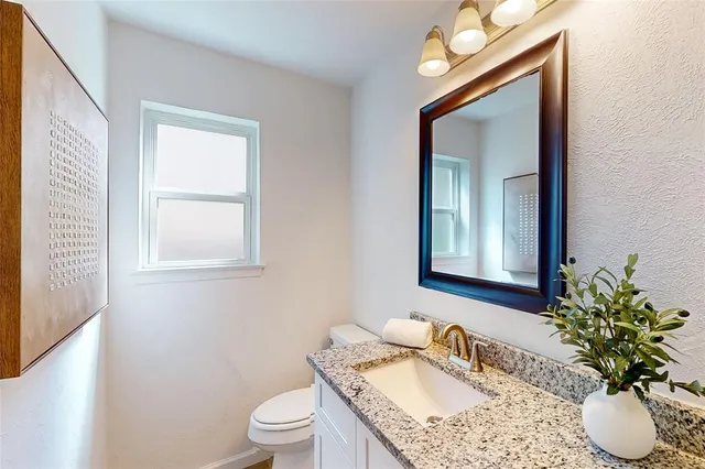 a bathroom with a granite countertop sink a mirror and a shower