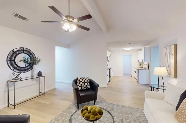 a large kitchen with a refrigerator and table chairs