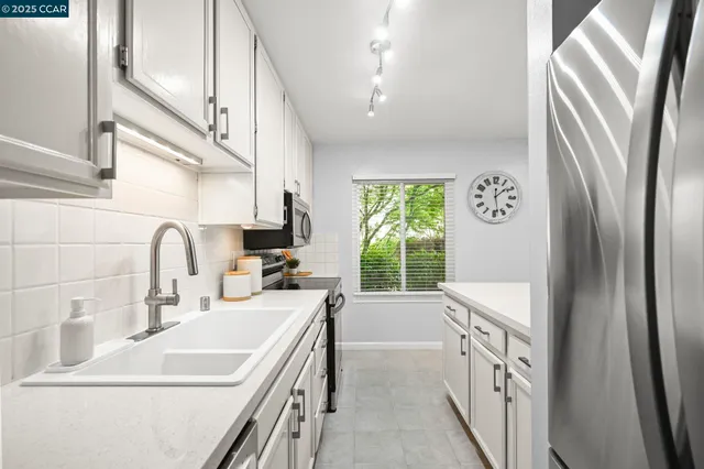 a kitchen with stainless steel appliances a sink a stove and a refrigerator