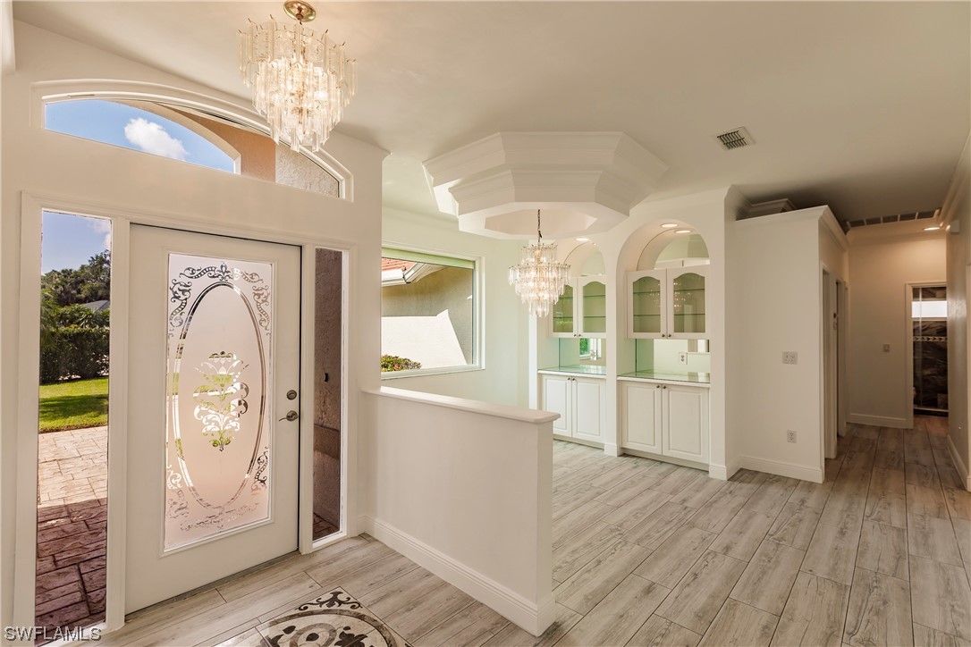 20600 Rivers Ford Estero, FL 33928 - Photo 2 of 28 a view of a hallway with wooden floor and chandelier
