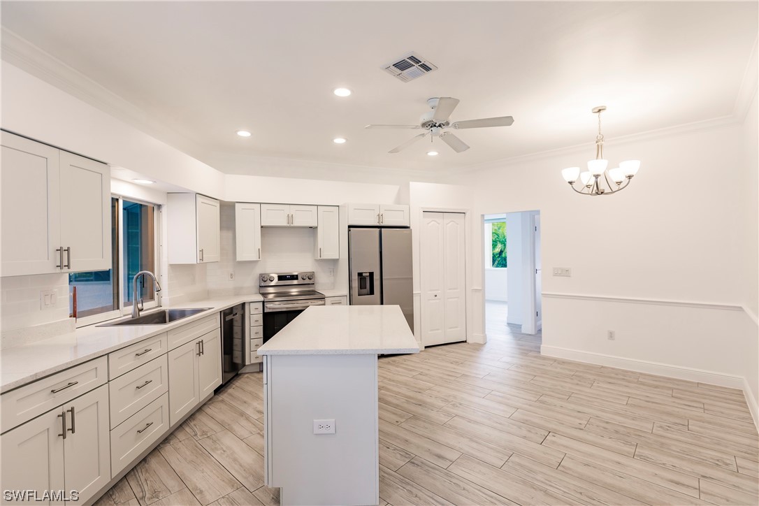 20600 Rivers Ford Estero, FL 33928 - Photo 6 of 28 a large kitchen with white cabinets and stainless steel appliances