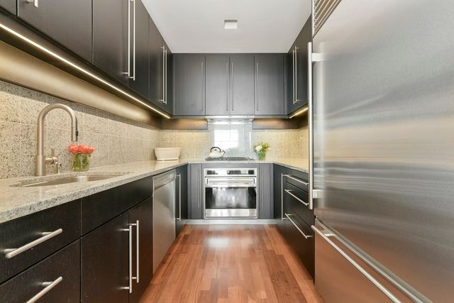 a kitchen with kitchen island a counter top space a sink and stainless steel appliances