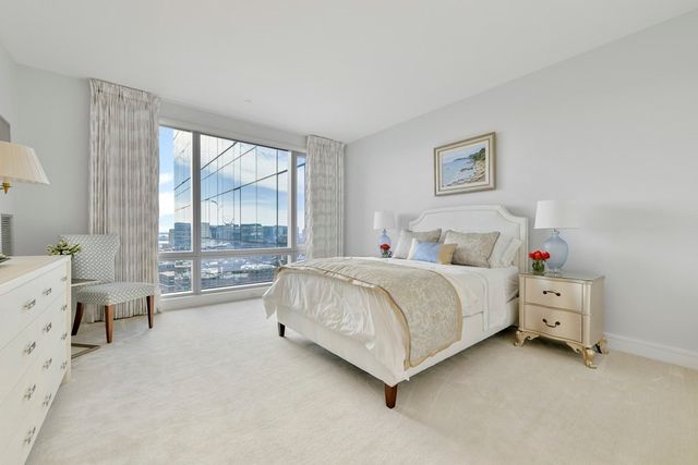 a spacious bedroom with a bed and a large window