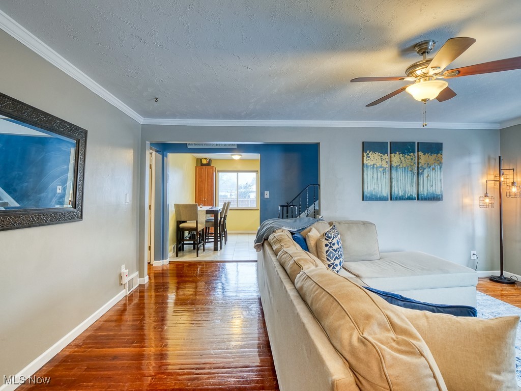 6794 York Road Cleveland, OH 44130 - Photo 10 of 45 Living room with hard wood floors, crown molding, a textured ceiling, a ceiling fan, and stairs