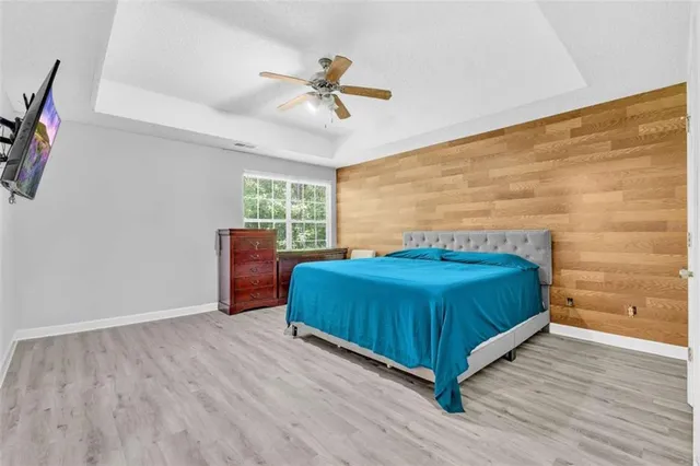 a spacious bedroom with a bed and wooden floor