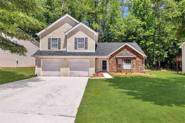 a front view of a house with yard and green space
