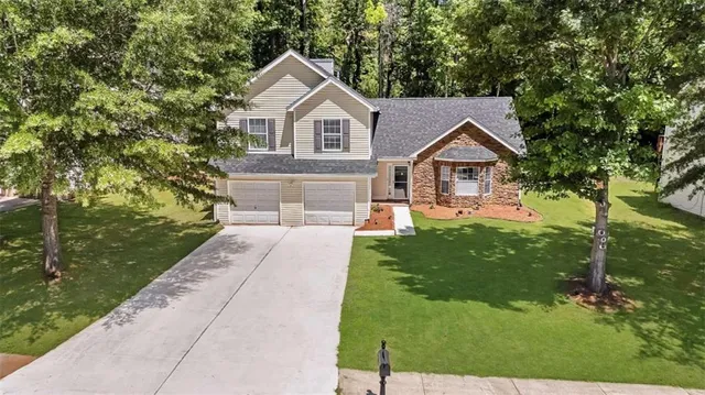 a front view of a house with a yard and trees