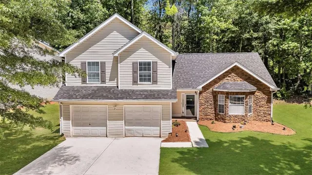 a front view of a house with a yard and garage