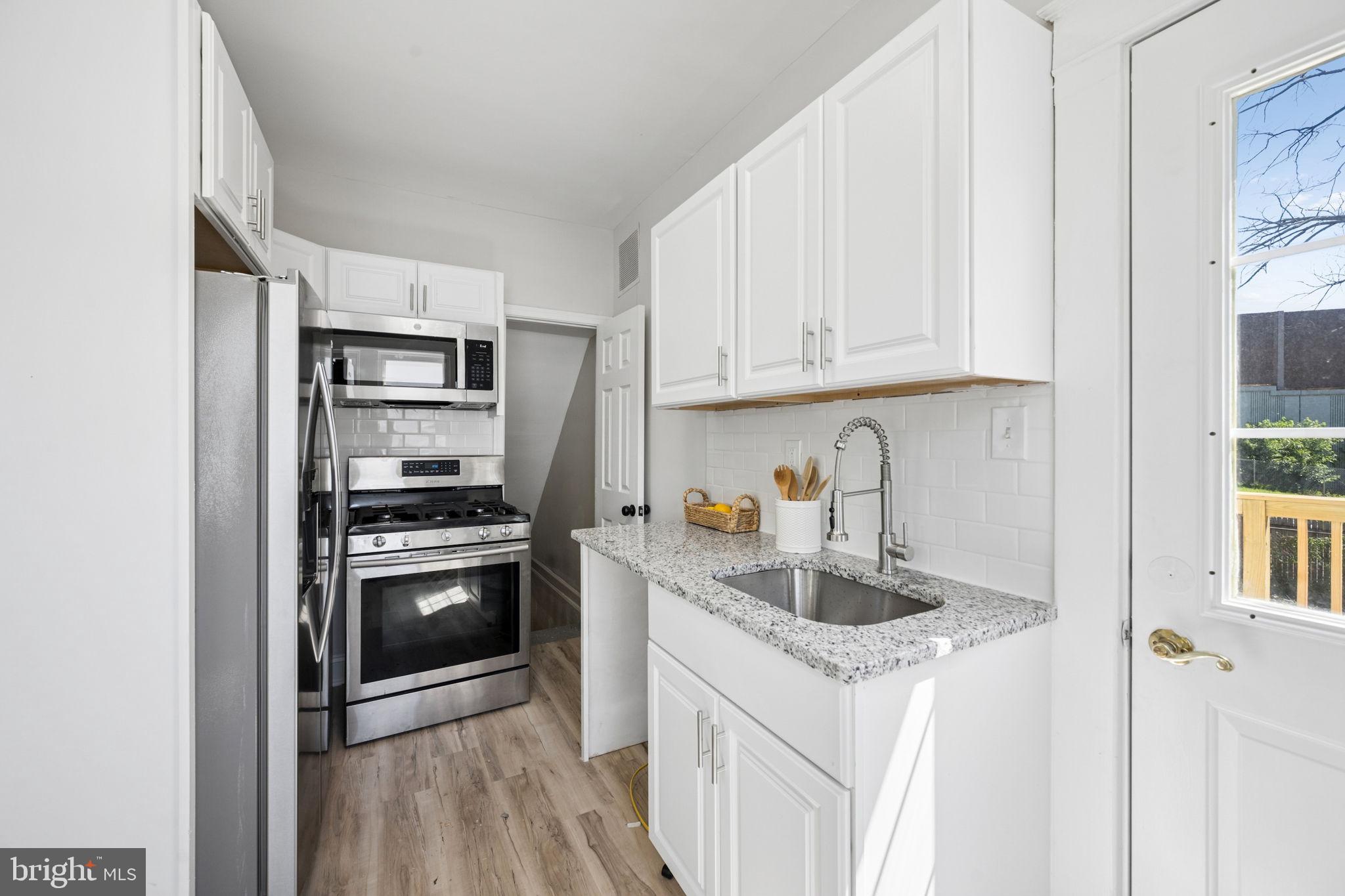 517 Valcour Road Baltimore, MD 21228 - Photo 14 of 47 a kitchen with stainless steel appliances granite countertop a refrigerator sink and stove