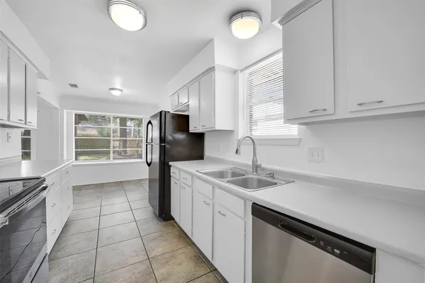 a kitchen with a sink window and refrigerator