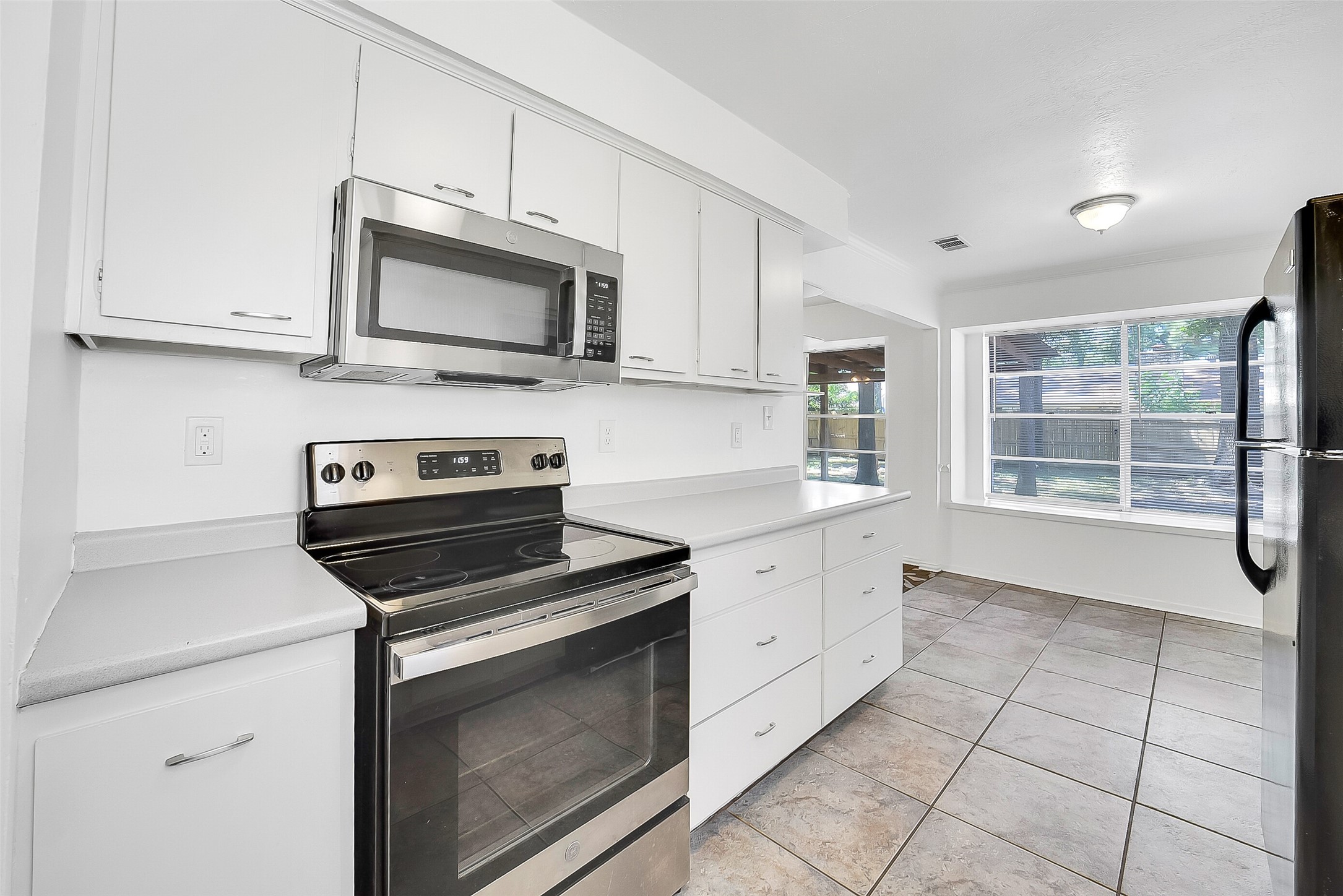 23123 Lestergate Drive Spring, TX 77373 - Photo 8 of 24 a kitchen with stainless steel appliances white cabinets and a stove top oven
