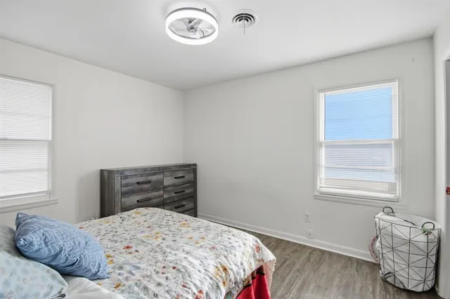 a bedroom with a bed and wooden floor