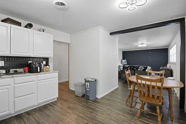 a kitchen with stainless steel appliances granite countertop a white cabinets and a stove top oven