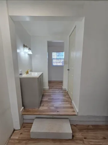 a view of a hallway with wooden floor and staircase