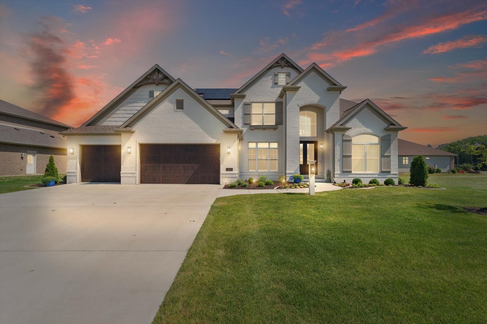 a front view of a house with yard and green space