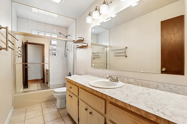 a bathroom with a granite countertop sink a toilet and shower