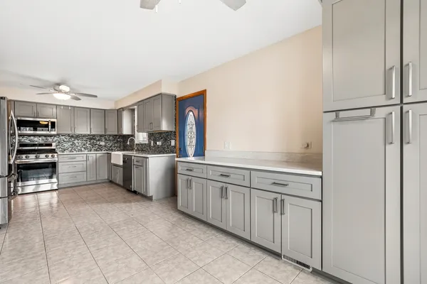 a kitchen with white cabinets and white appliances