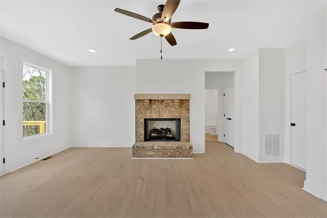 a view of an empty room with a window and a fireplace