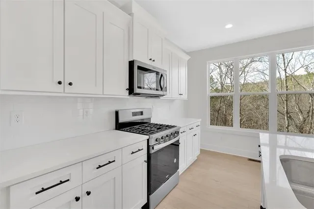 a kitchen with granite countertop white cabinets and white appliances